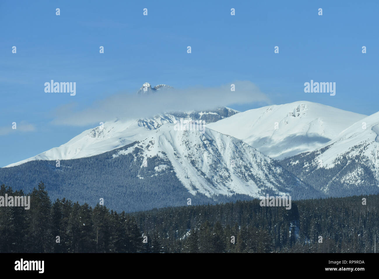 Mountain-punta visibile sopra la nuvola di fronte montagne rocciose Foto Stock