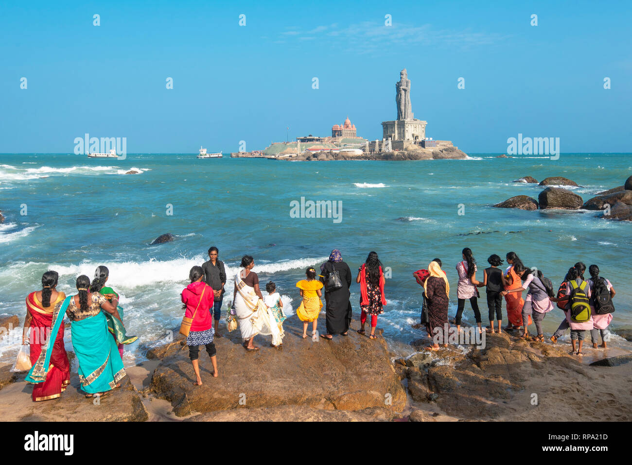 Turisti e popolazione locale sulla riva di Kanyakumari guardando il Vivekananda Rock Memorial e Thiruvalluvar Statue in una giornata di sole con cielo blu. Foto Stock