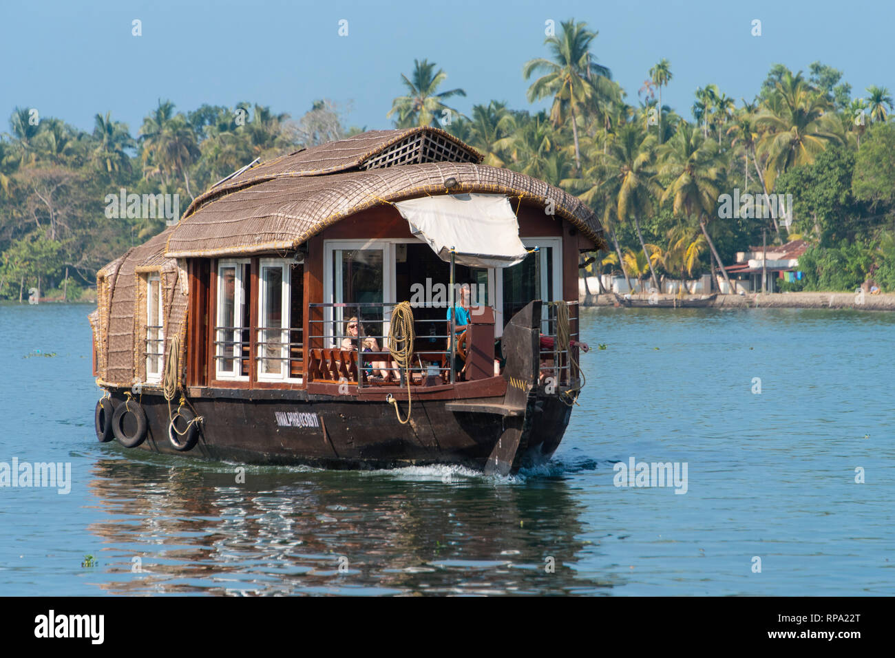 Un tipico esempio di un tradizionale liveaboard crociere in barca galleggianti in Kerala backwaters in una giornata di sole con cielo blu e palme. Foto Stock