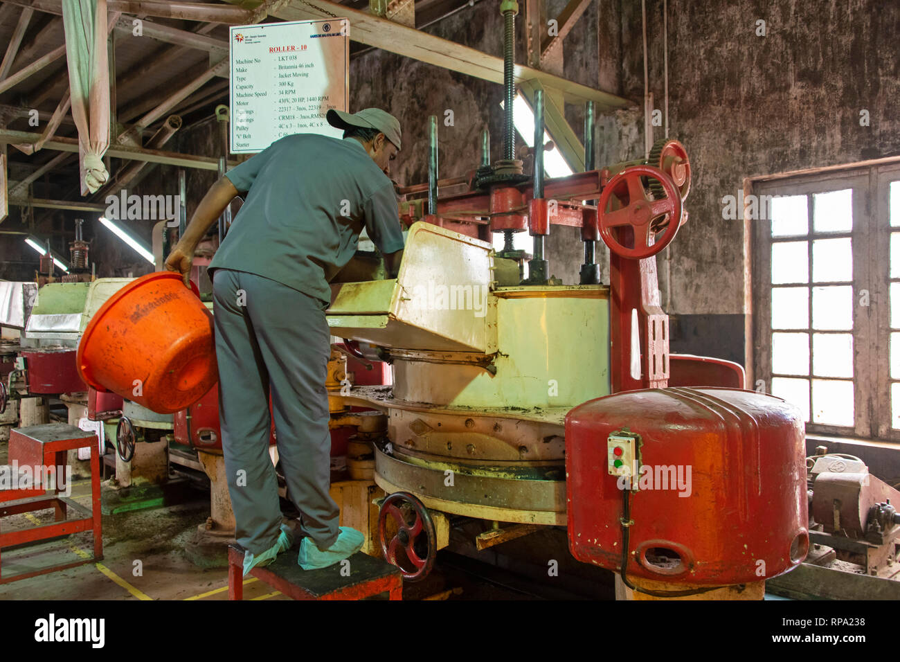 Lavoratore a lavorare in Lockhart tea factory utilizzando i metodi tradizionali e macchinari. Questo è il processo di essiccazione. Foto Stock