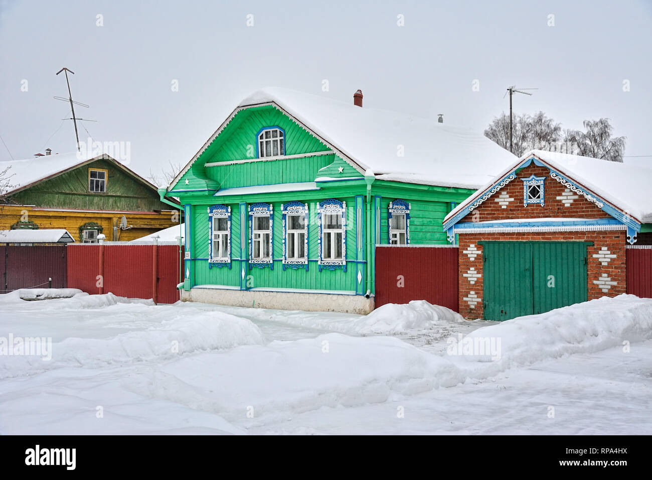 = Verde casa in legno con Garage su Pushkarskaya Street in inverno = neve al coperto il verde brillante russo in legno con garage casa su Pushkarskaya st Foto Stock