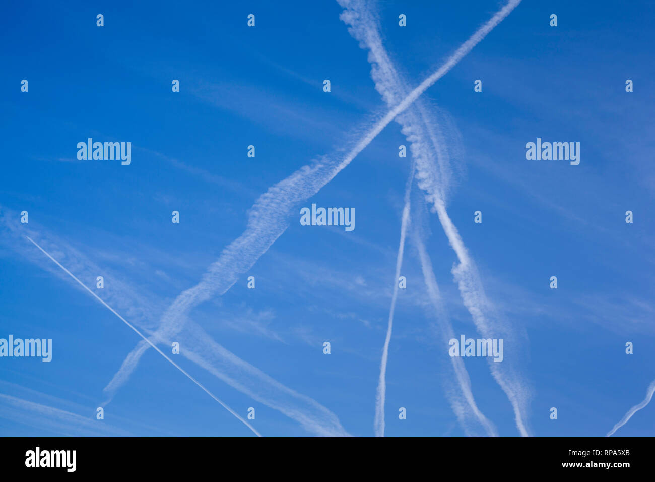 Modelli astratti di vapore sentieri nel cielo blu, talvolta noto come contrails o scie di condensazione. Foto Stock