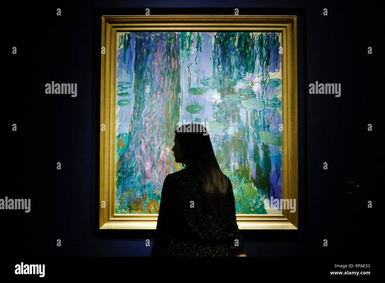 Casa d'aste Christie's, Londra, Regno Unito. 21 feb 2019. Un Christie's dipendente pone con illustrazioni di Claude Monet 'Saule pleurer et bassin aux nympheas' alla casa d'aste Christie's di Londra, giovedì 21 febbraio, 2019.Il pezzo sarà venduta all'asta durante Christie's sera vendita mercoledì. Esso è stimato per ottenere una figura di vendite di oltre £40milioni di euro.fotografia : credito: Luca MacGregor/Alamy Live News Foto Stock