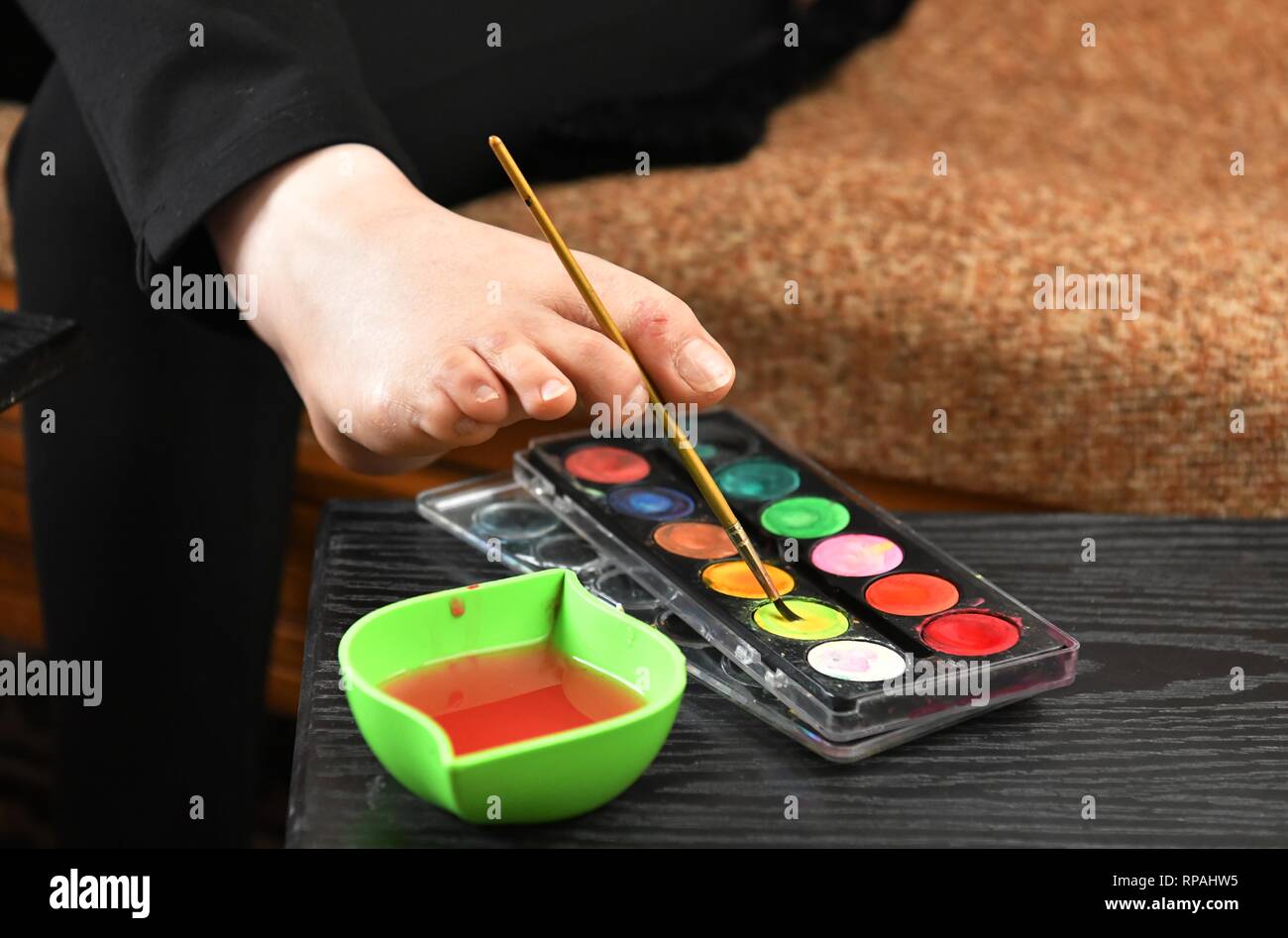 Damasco, Siria. Xx Febbraio 2019. Dua al-Bustati, 28 attira con il suo piede nella sua casa nel sobborgo di Sehnaya nella campagna di Damasco Capitale della Siria, il 20 febbraio, 2019. Dua al-Bustati nata senza braccia. Tuttavia ella divenne in grado di rompere i limiti con il suo talento di disegno vari dipinti con i suoi piedi. Credito: Ammar Safarjalani/Xinhua/Alamy Live News Foto Stock