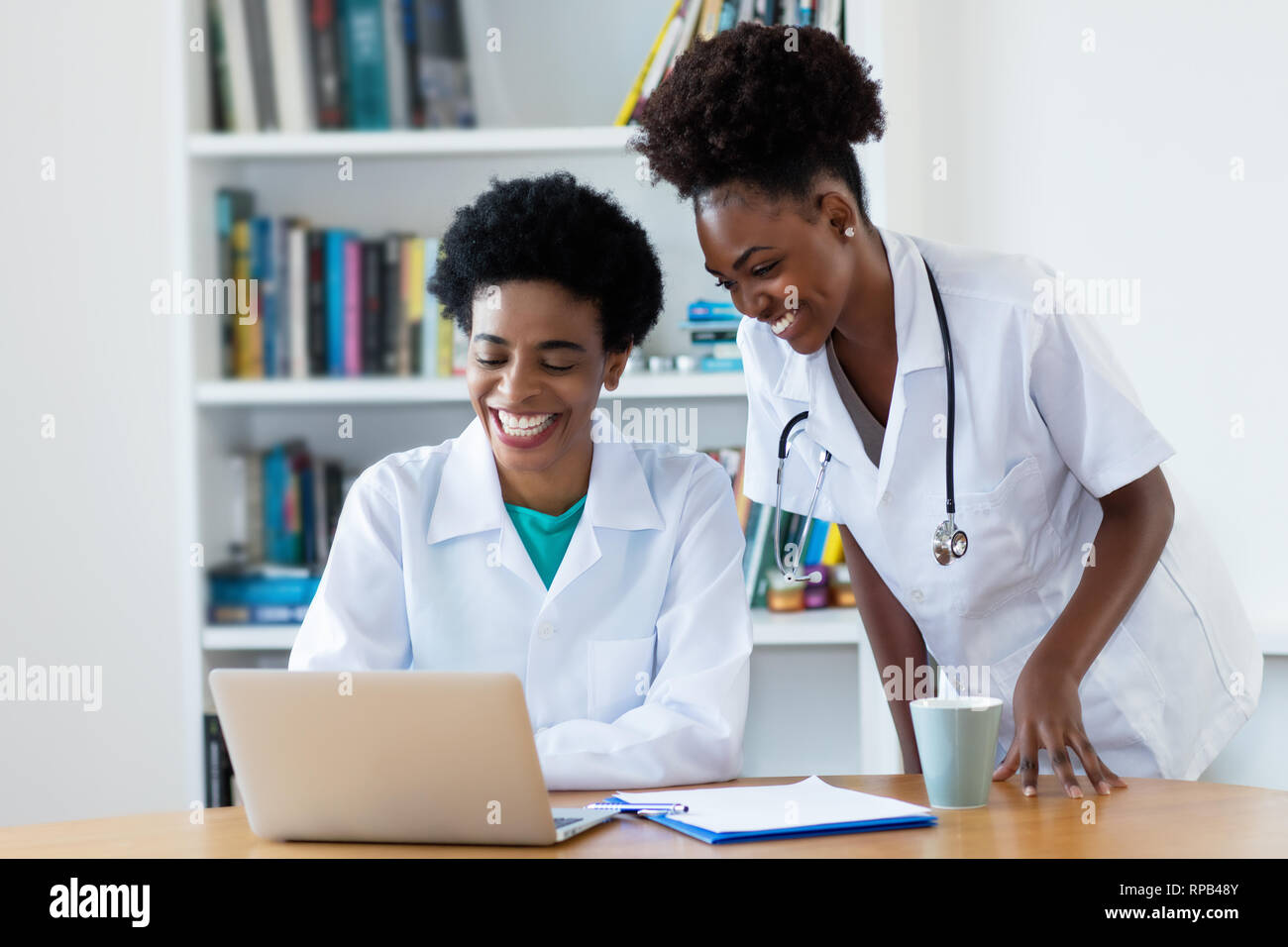 Ridendo americano africano medico donna con giovani infermiera all ospedale Foto Stock
