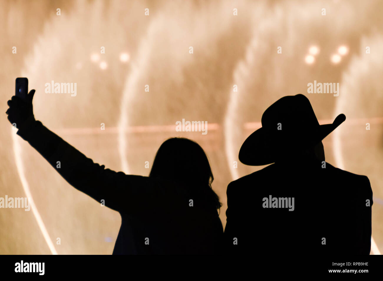 LAS VEGAS, NEVADA, STATI UNITI D'AMERICA - Febbraio 2019: uomo che indossa il cappello da cowboy e la donna prendendo un selfie stagliano fontane dell'Hotel Bellagio in La Foto Stock