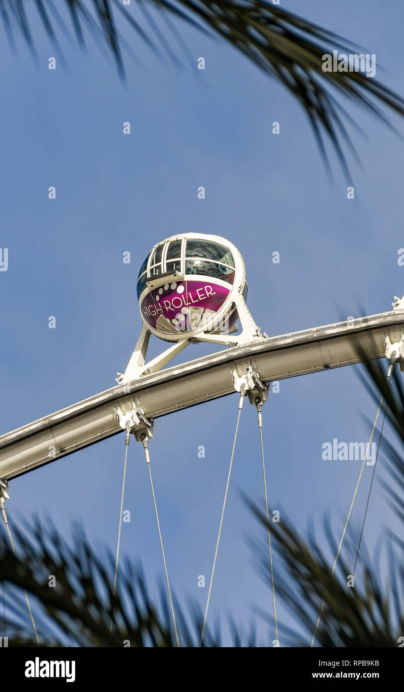 LAS VEGAS, NEVADA - Febbraio 2019: capsula in alto il rullo ruota gigante ride contro un cielo blu con vista incorniciata da palme. Foto Stock