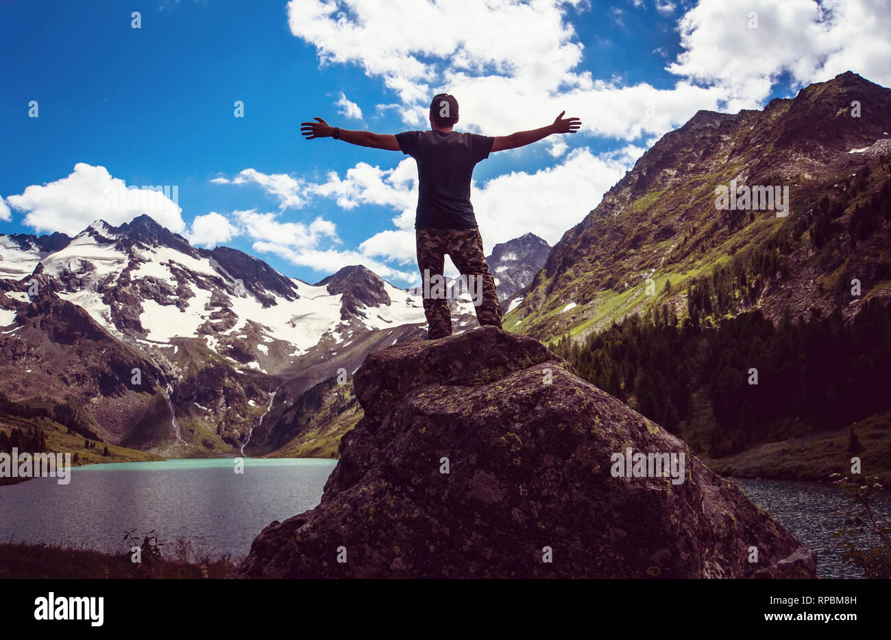 Uomo felice Traveler mani alzate montagne e lago paesaggio sullo sfondo stile di vita viaggio avventura concetto vacanze estive Foto Stock