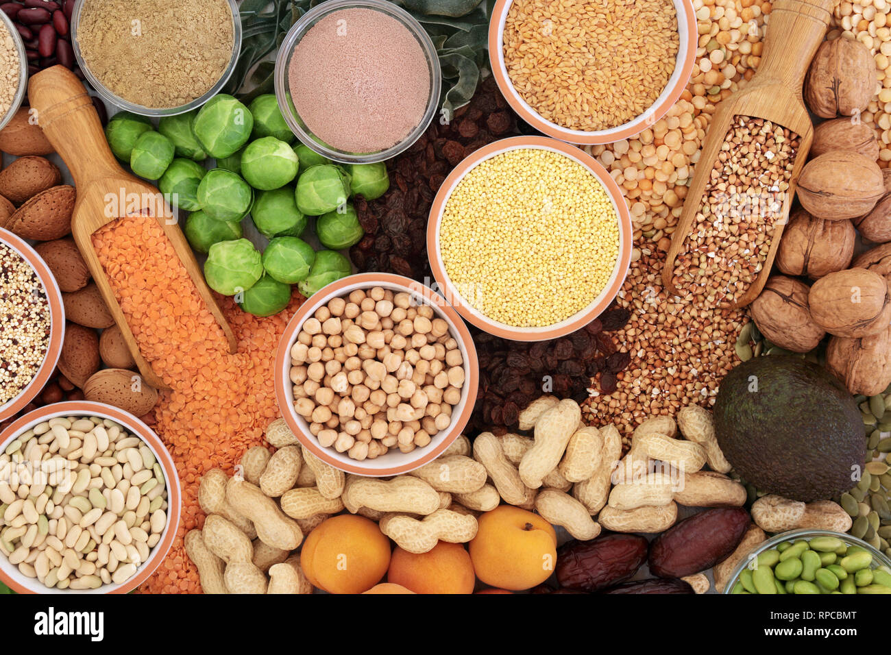 Alimenti ad alto contenuto proteico con verdure, legumi, frutta secca, noci, semi, cereali e integrare le polveri. Foto Stock