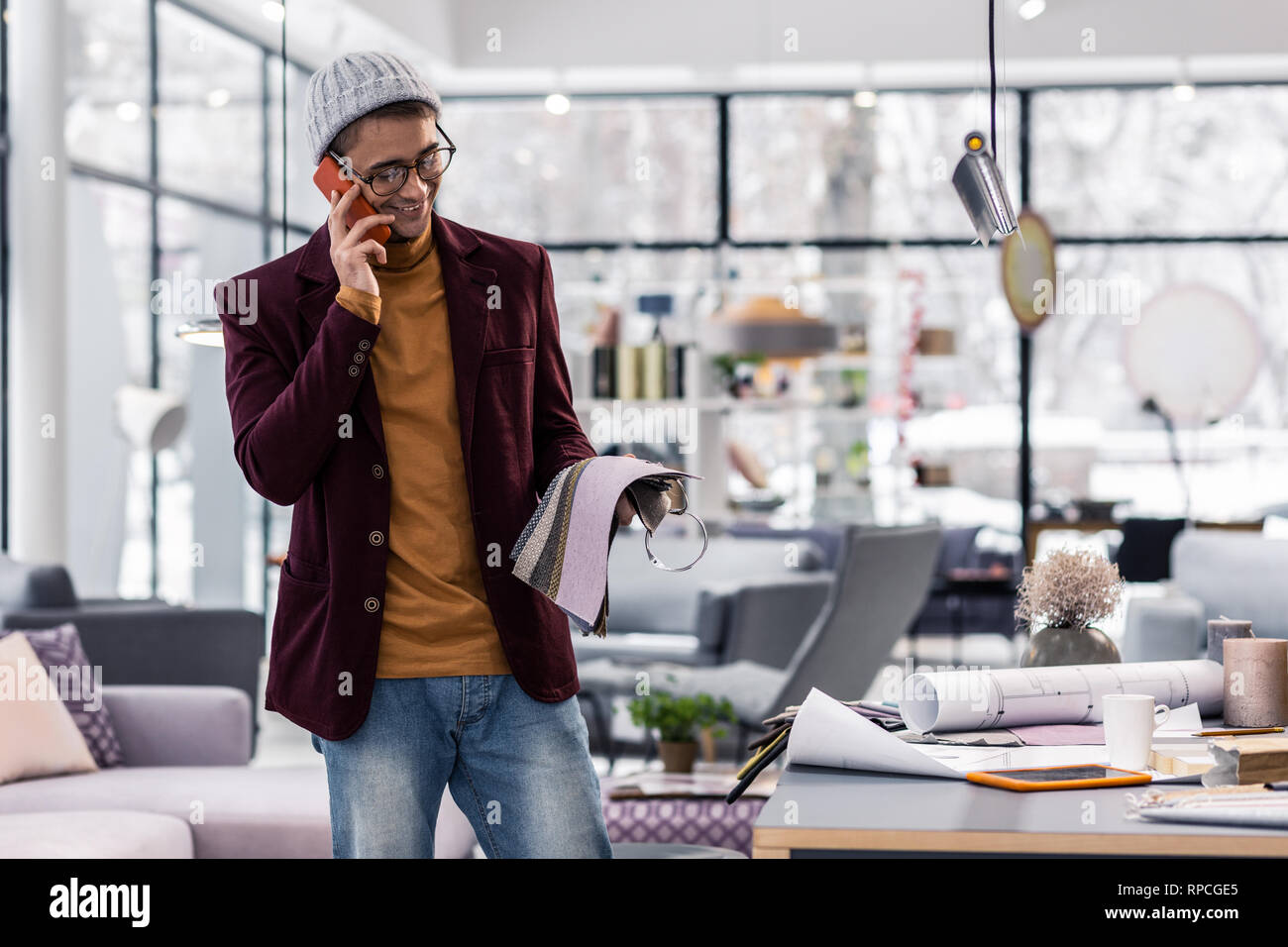 Buona-attraente sorridente specialista sugli appalti negoziati sul telefono con tessuti fornitore Foto Stock