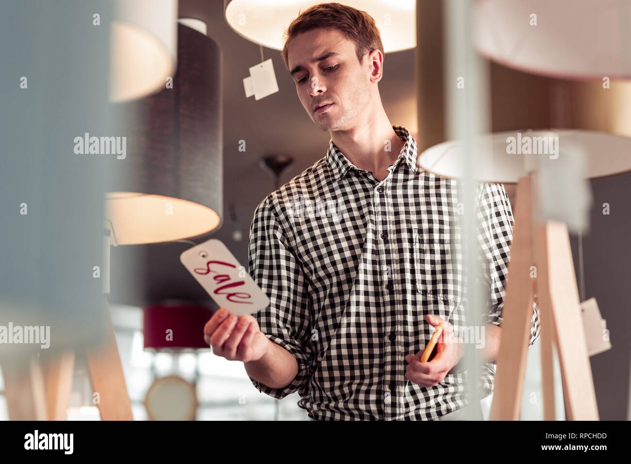 Attraente maschio elegante sorprendentemente guardando vendita sign tag Foto Stock