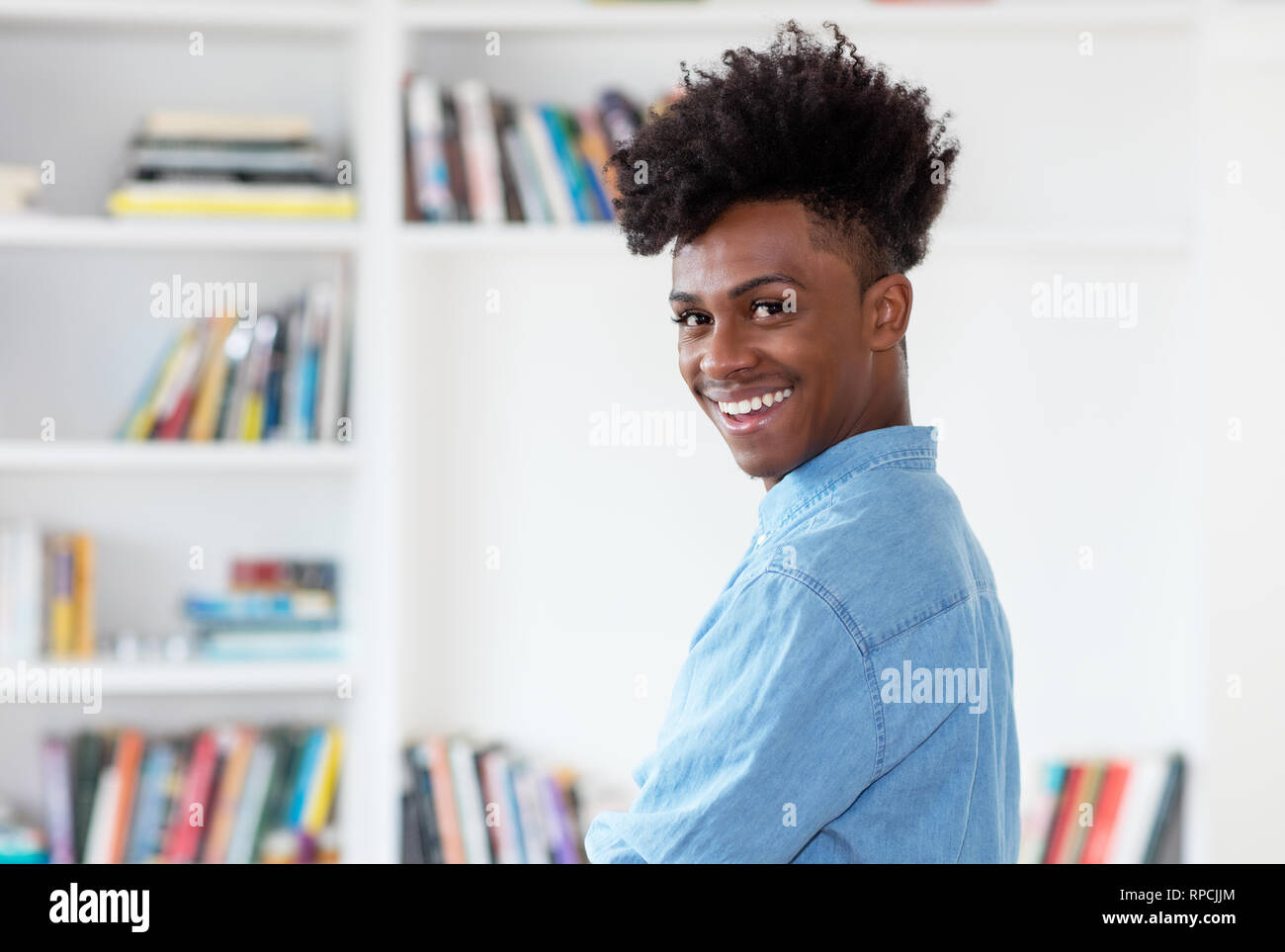 Ridendo americano africano giovane uomo adulto indoor a casa Foto Stock