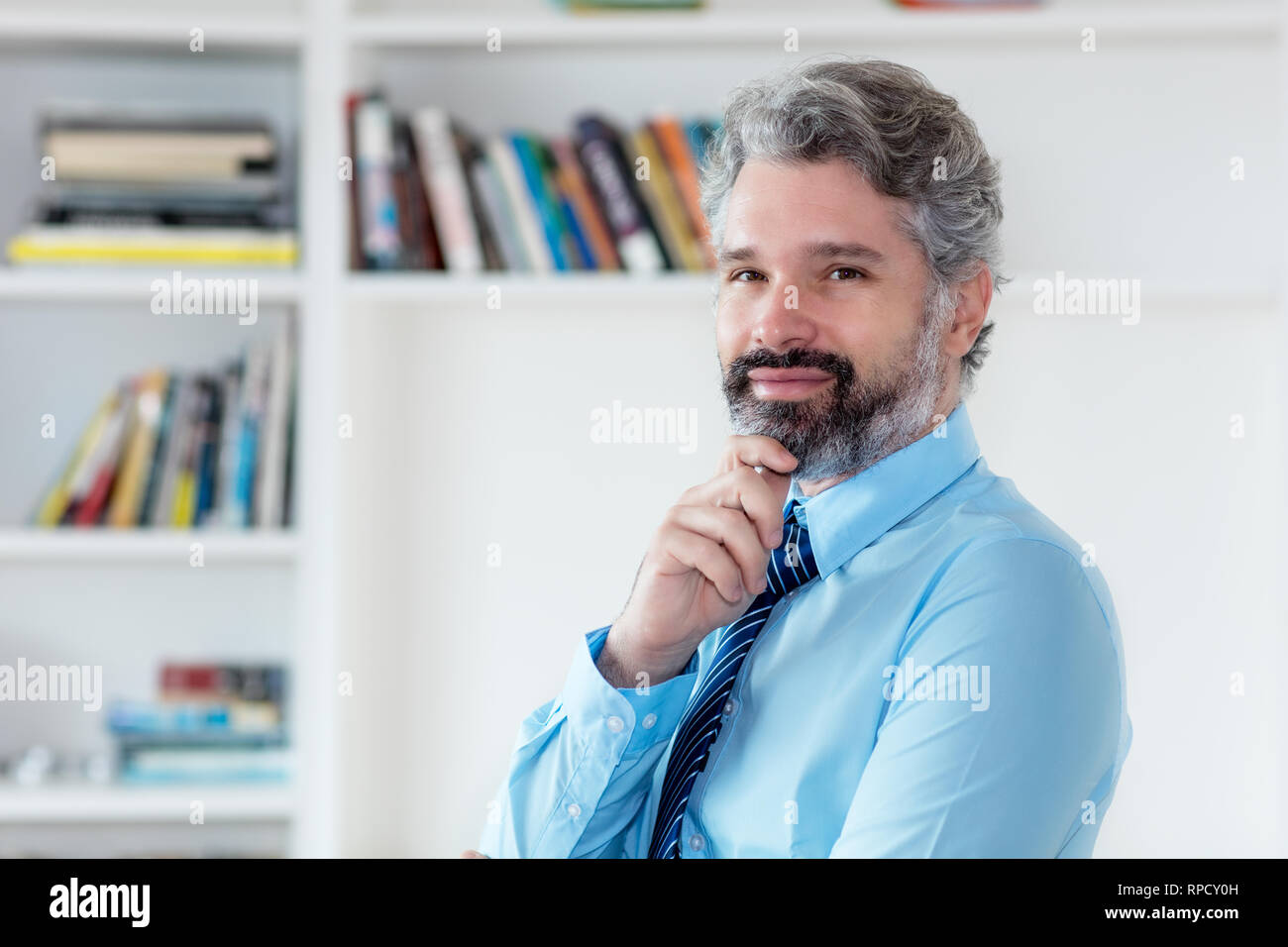 Smart imprenditore con i capelli grigi e cravatta in ufficio Foto Stock