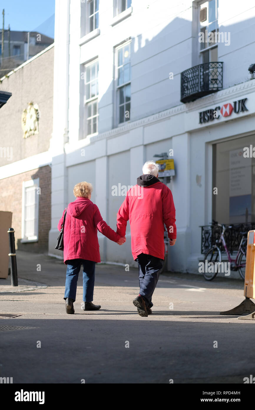 Una coppia in pensione tenendo le mani in Falmouth, Cornwall Foto Stock
