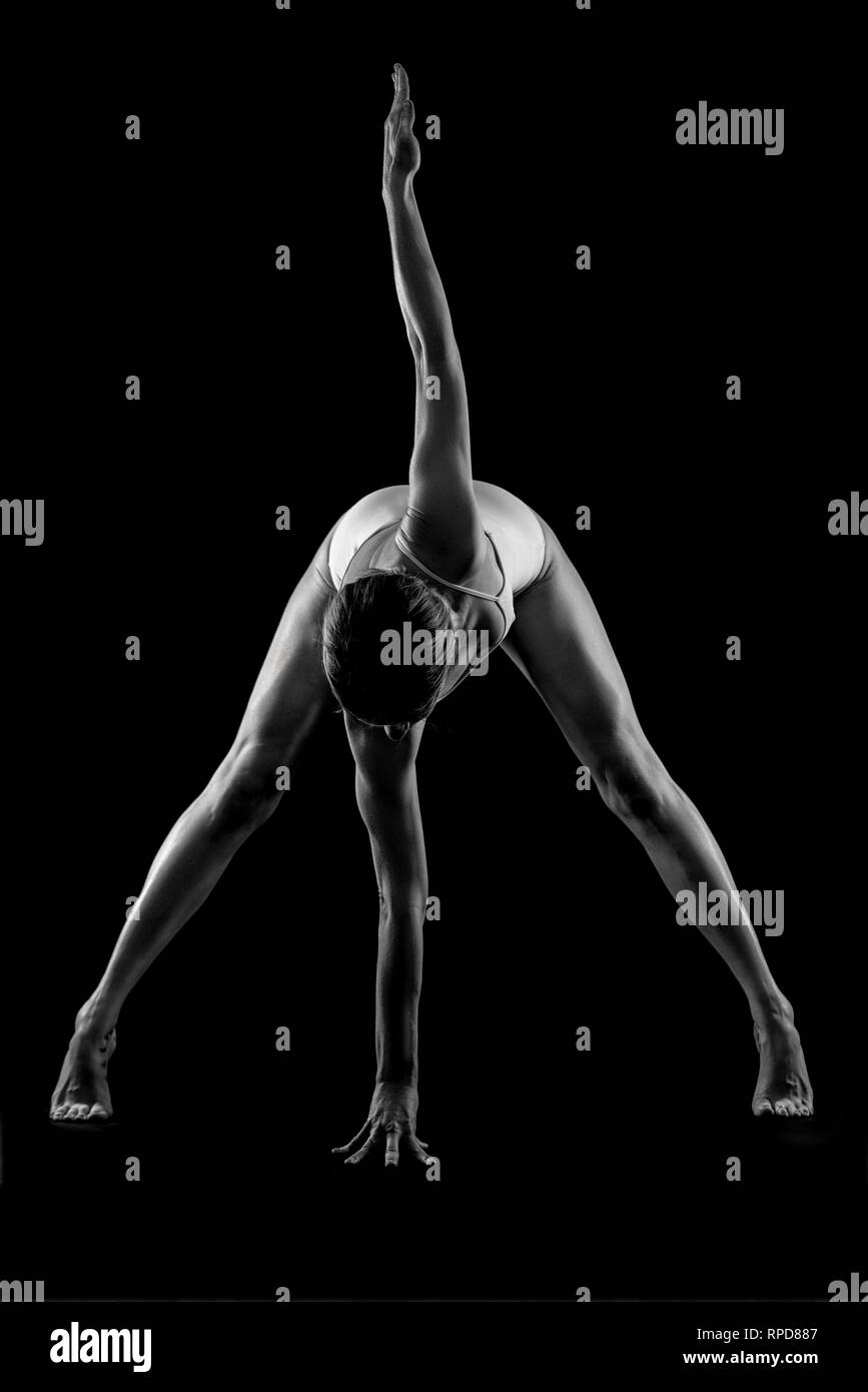 Donna pratica lo yoga, "piegamento in avanti' pongono in studio, in bianco e nero Foto Stock