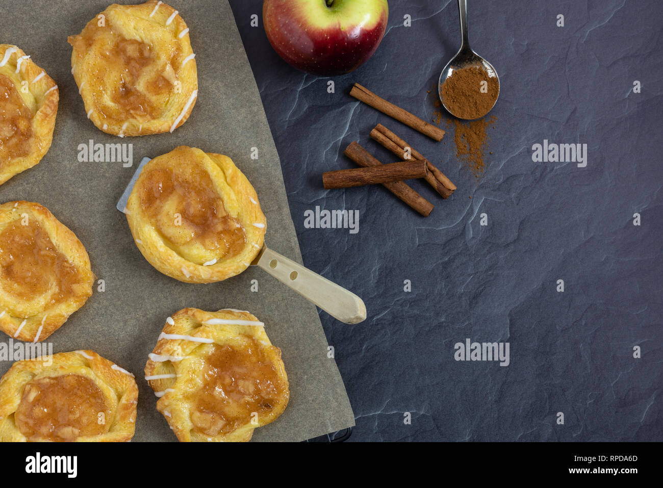 In ardesia scura con sfondo danese su carta pergamena con la spatola la cannella e Apple Foto Stock