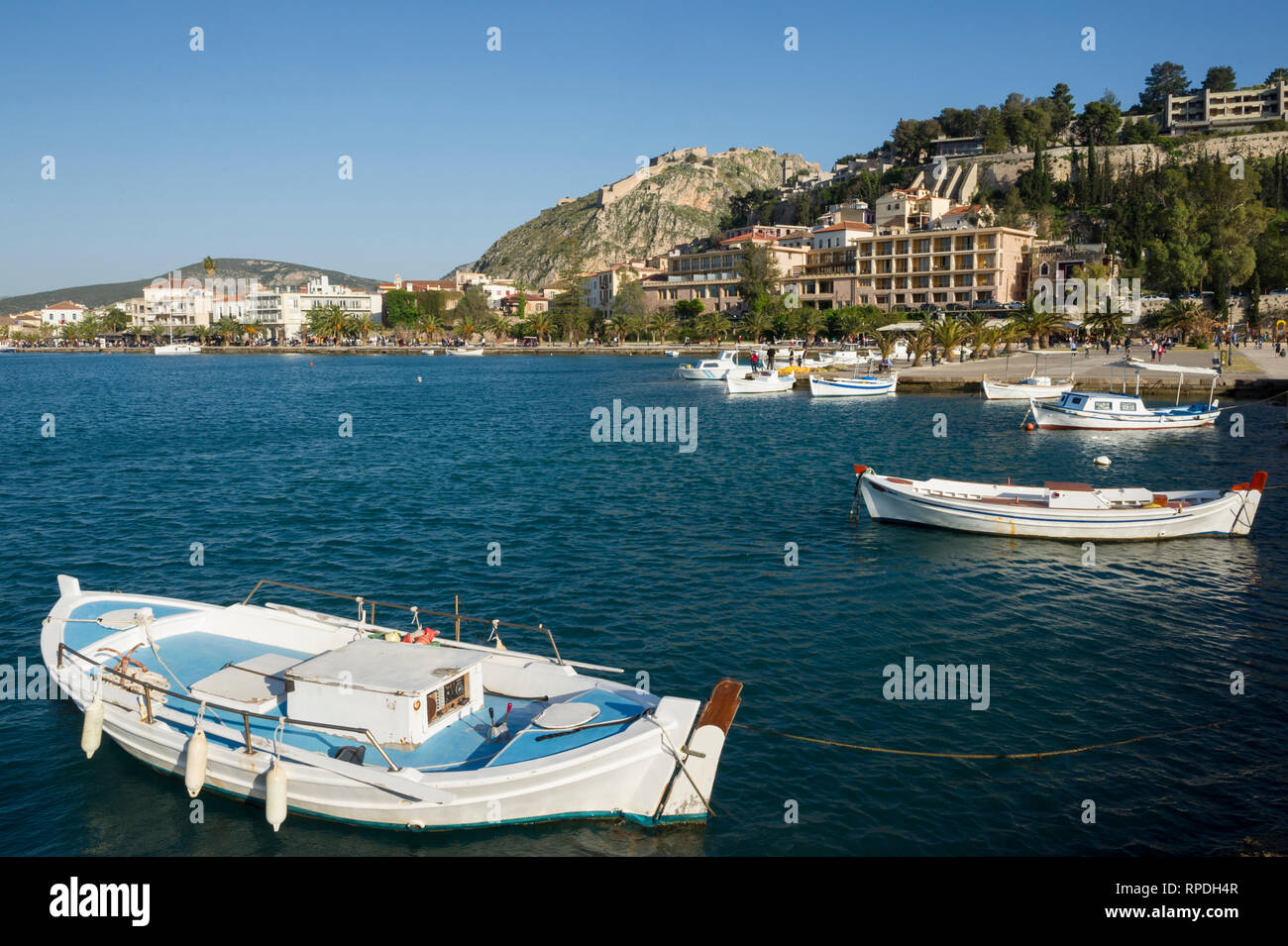 Waterfront e Palamidi castello che si erge sulla collina, Nafplio, Grecia Foto Stock