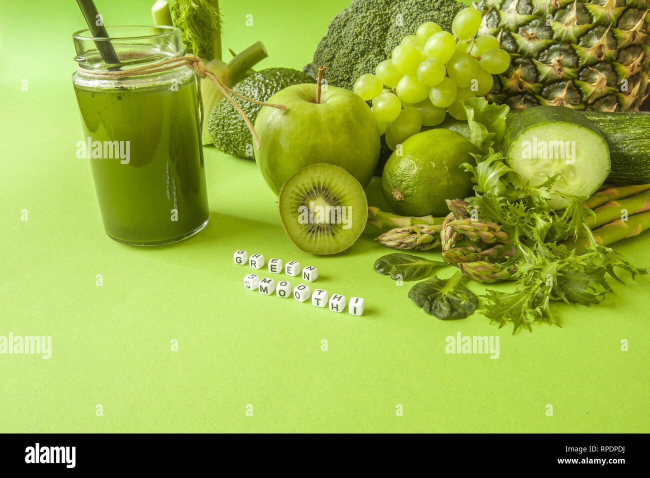 Salute verde i frullati di frutta e verdura, foglie di cavolo riccio, calce, mela, kiwi, uva, banana, avocado, lattuga ananas salat. Copia dello spazio. Raw, vegan Foto Stock