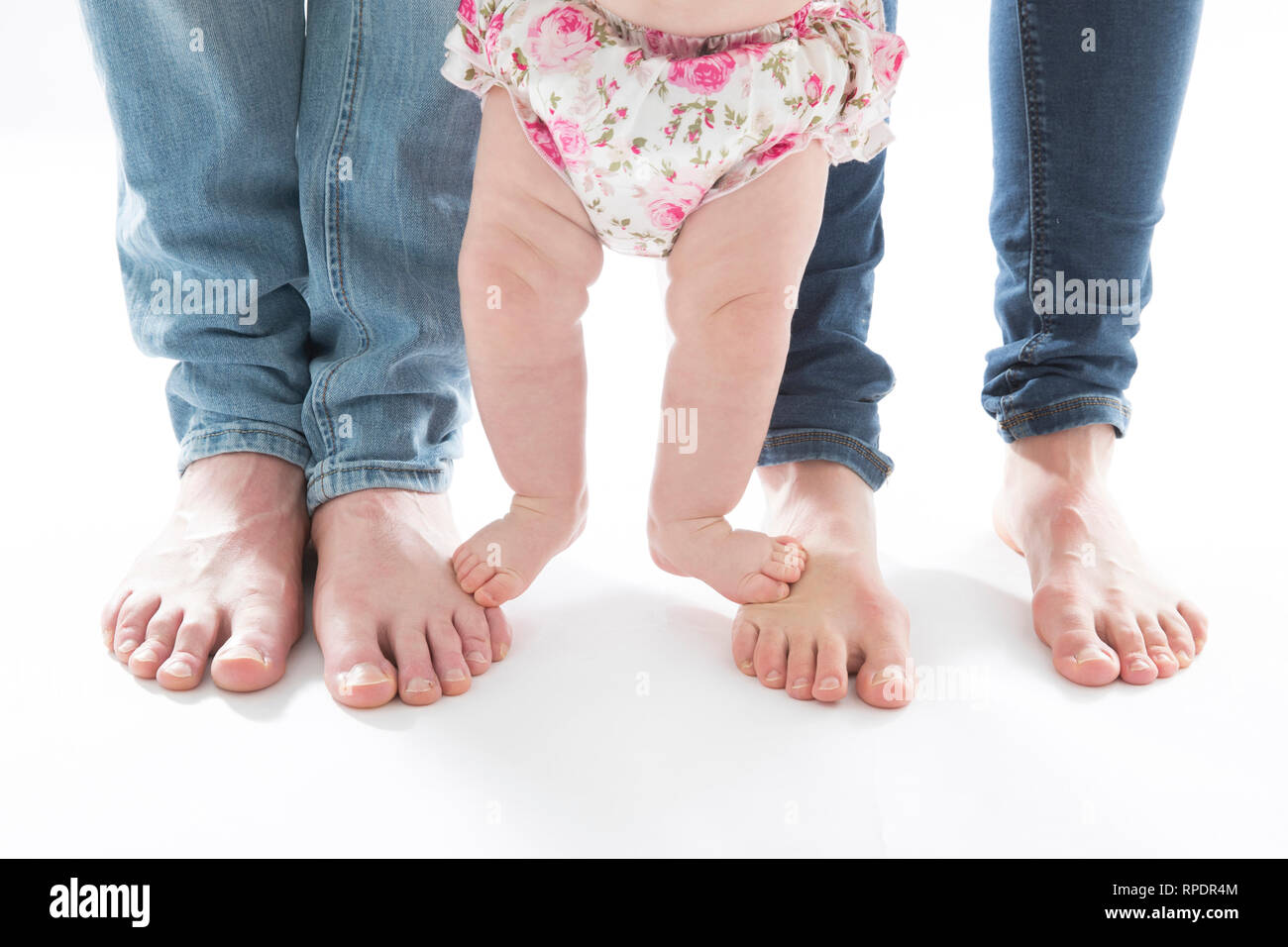Inquadratura orizzontale di mamma, papà e babygirl i piedi. Famiglia piedi su sfondo bianco Foto Stock