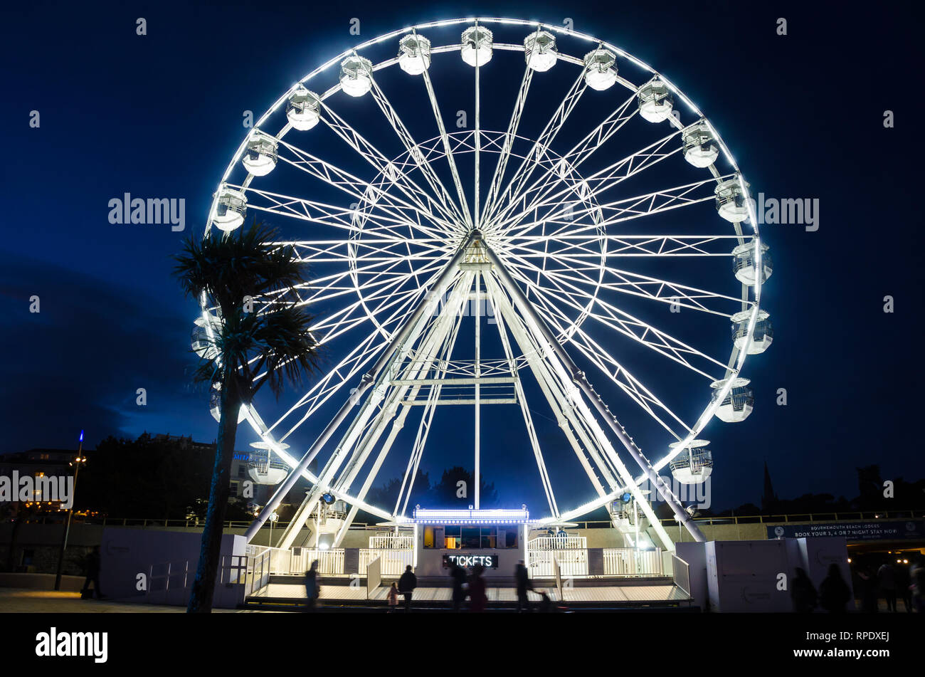 La grande ruota a Bournemouth si eleva alto nel cielo notturno ed è brillantemente illuminato di bianco. Foto Stock