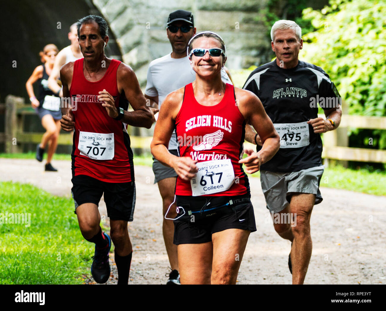 Babilonia, New York, Stati Uniti d'America - 12 August 2018: guide su un percorso sterrato nel bosco racing a 10K per la carità in estate godendo la loro giornata. Foto Stock