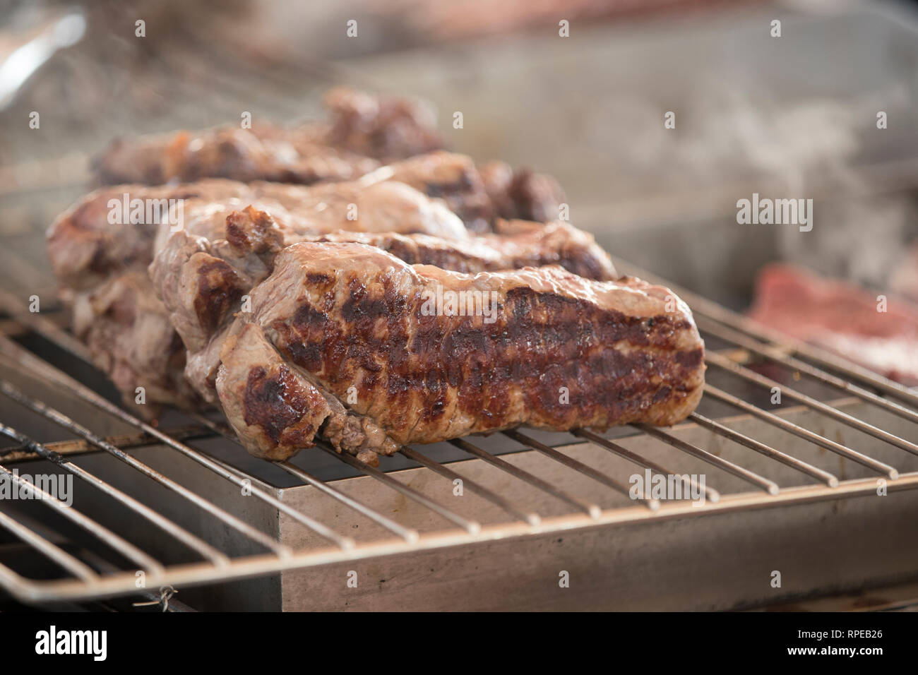 Primo piano della steakes su un barbeque finisching per cucinare. Foto Stock