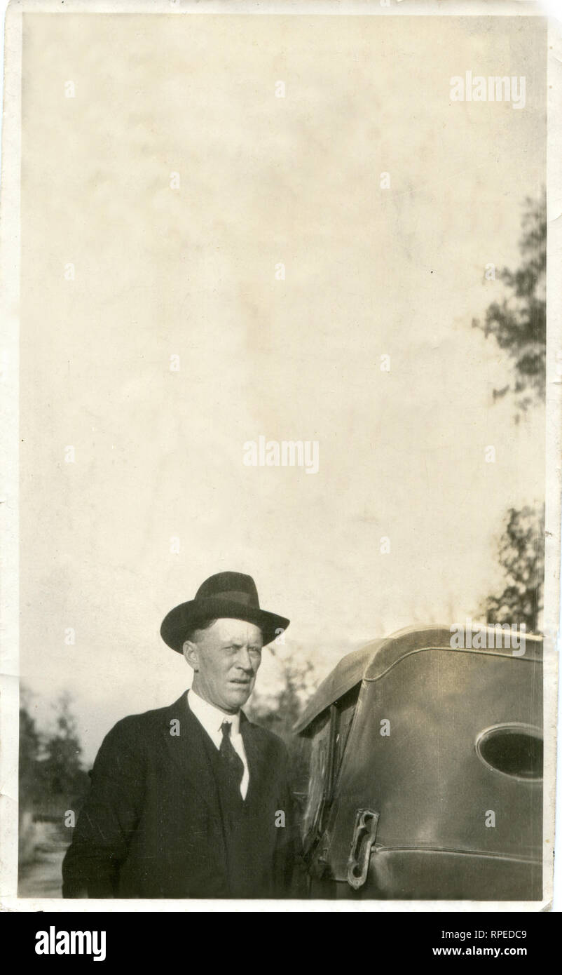 America. Stati Uniti d'America. 1920s . Un uomo di mezza età in un cappotto e cappello sorge nei pressi della sua vettura. Foto Stock