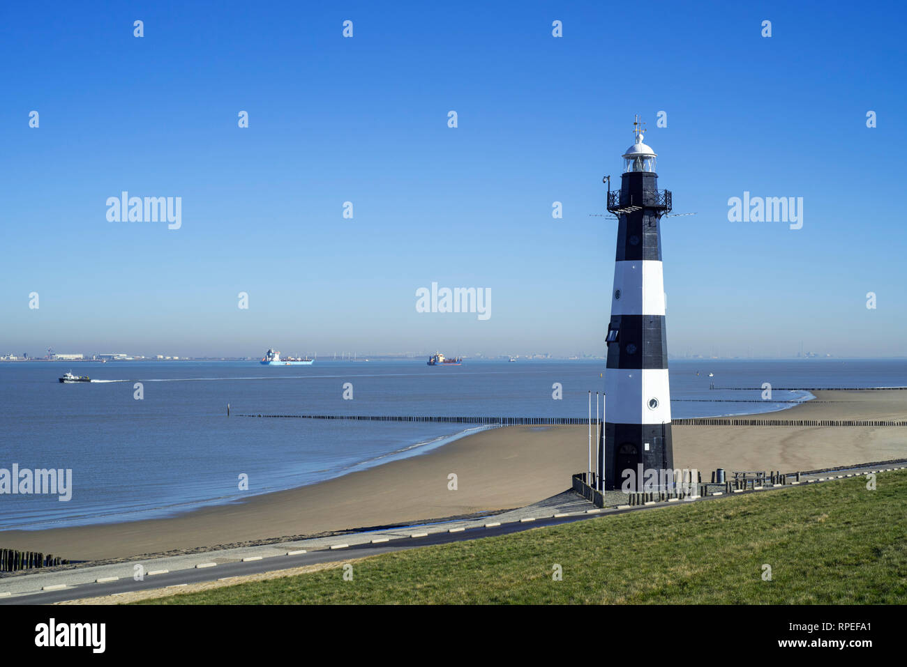 Argine / dike e Nieuwe Sluis, Lighthouse vicino a Breskens che segna l'entrata per la Schelda occidentale / Westerschelde, Zeeland, Paesi Bassi Foto Stock