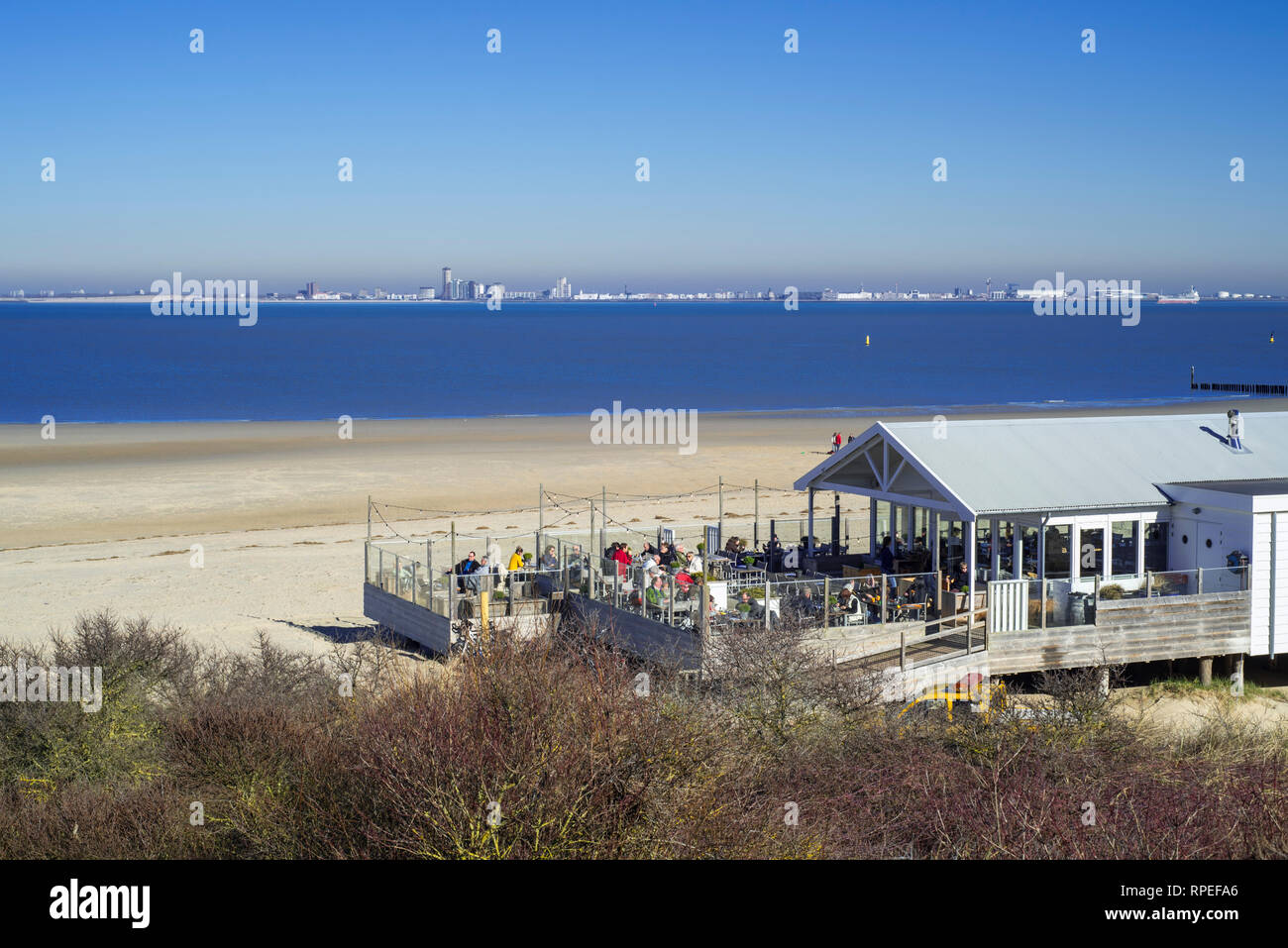 Skyline della città Vlissingen e ristorante beach pavilion vicino Breskens lungo la Schelda occidentale / Westerschelde, Zeeland, Paesi Bassi Foto Stock