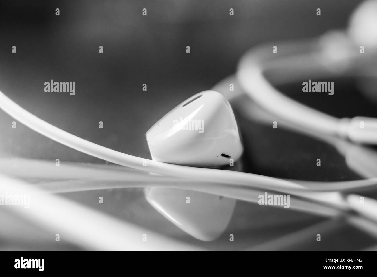 Gli auricolari bianco isolato su vetro sfondo bokeh di fondo Foto Stock