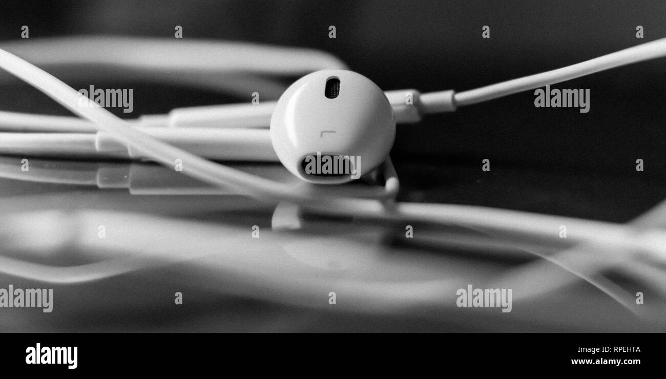 Gli auricolari bianco isolato su vetro sfondo bokeh di fondo Foto Stock