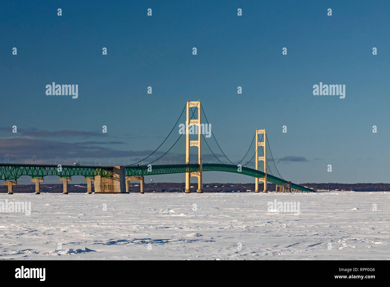 Mackinaw City, Michigan - Il ponte Mackinac attraverso la congelati stretto di Mackinac. Lo stretto collega il Lago Michigan e il Lago Huron. La cinque-miglio-l Foto Stock