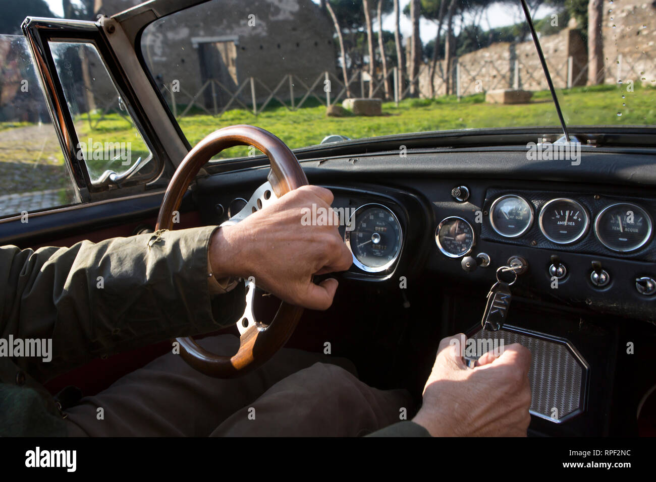 Roma - un uomo aziona un oldtimer MG sportscar sulla Via Appia. La costruzione della via Appia è iniziata nel 312 A.C. Foto Stock