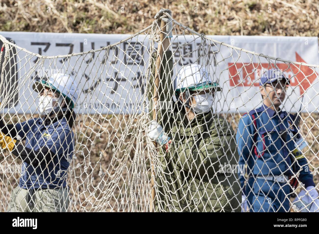 Tokyo, Giappone. Il 22 febbraio, 2019. I custodi del giardino zoologico tenere premuto su una rete durante la fase di un animale sfuggito trapano a Tama parco zoologico. La fuga annuale trapano è detenuto per addestrare i custodi del giardino zoologico che cosa fare in caso di un animale in fuga. Questo anno un membro del personale che indossa un costume orangutan venne catturato e subì con grandi reti, bastoni e pistole tranquillante per assicurarsi l'Orango Tango non arrivare lontano. Credito: Rodrigo Reyes Marin/ZUMA filo/Alamy Live News Foto Stock