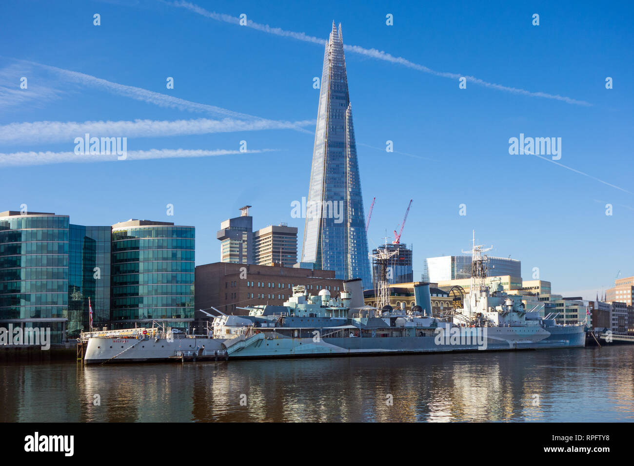 La corazzata HMS Belfast ormeggiato sul fiume Tamigi a Southwark Londra con il Coccio edificio in background nello skyline di Londra Foto Stock