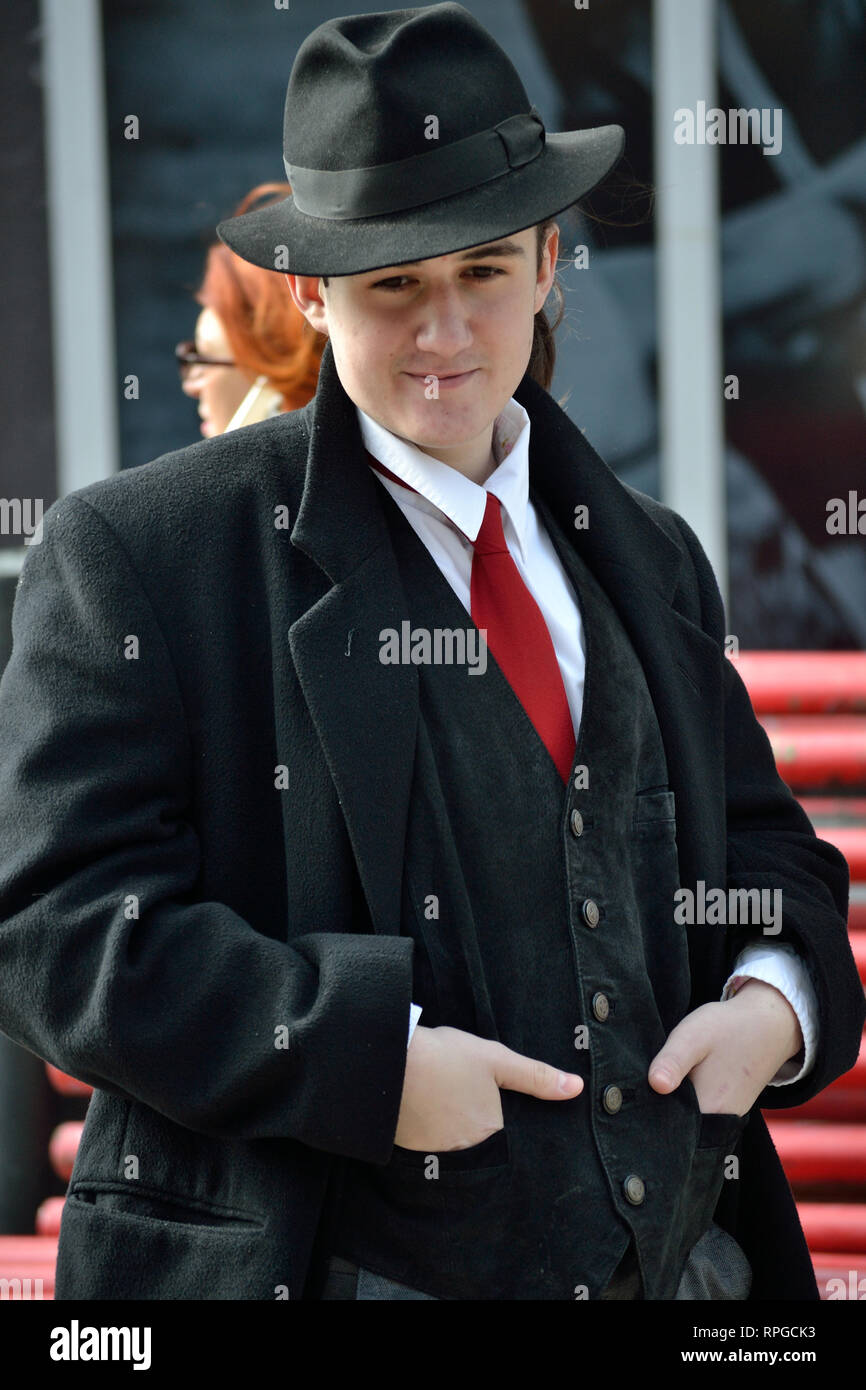 Giovane uomo in cappotto, indossare un cappello, in piedi su una strada, Svilajnac, Serbia, Europa Foto Stock