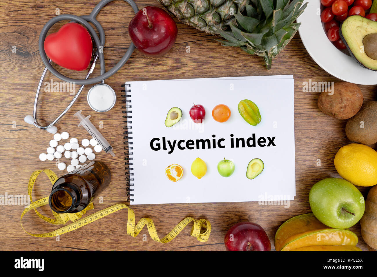 Indice Glicemico Fitness e perdita di peso concetto, manubri, bianco scala, frutta e nastro di misurazione su un tavolo di legno, vista dall'alto Foto Stock