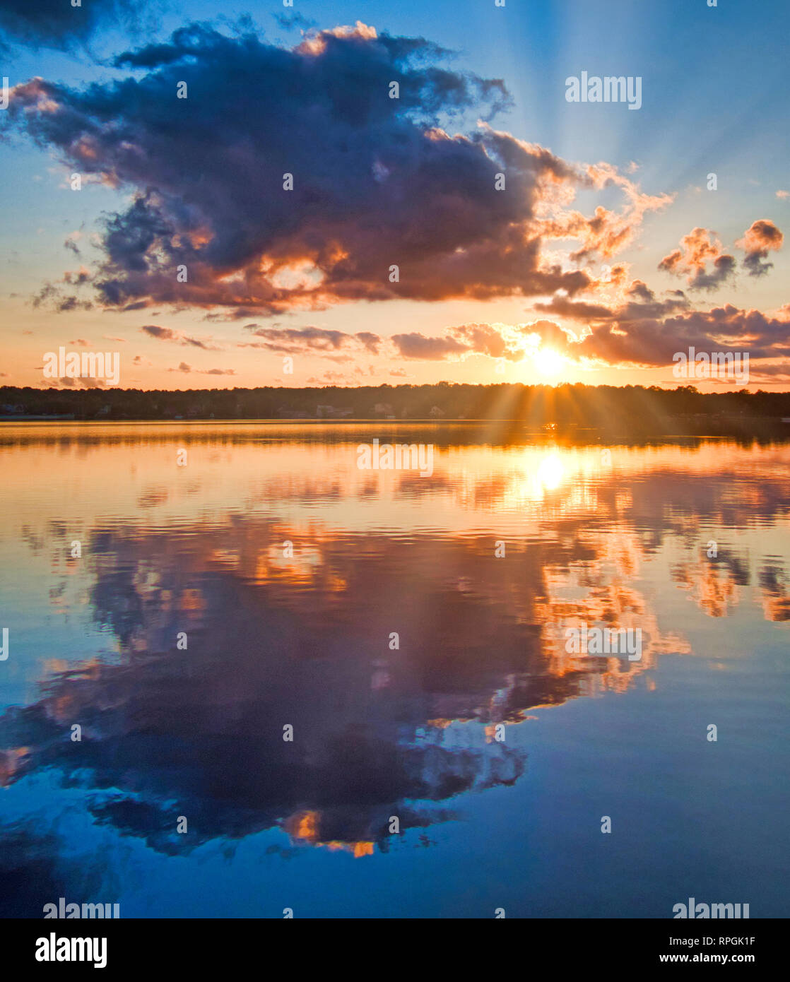 Lago di montagna al tramonto, raggi crepuscolari Foto Stock