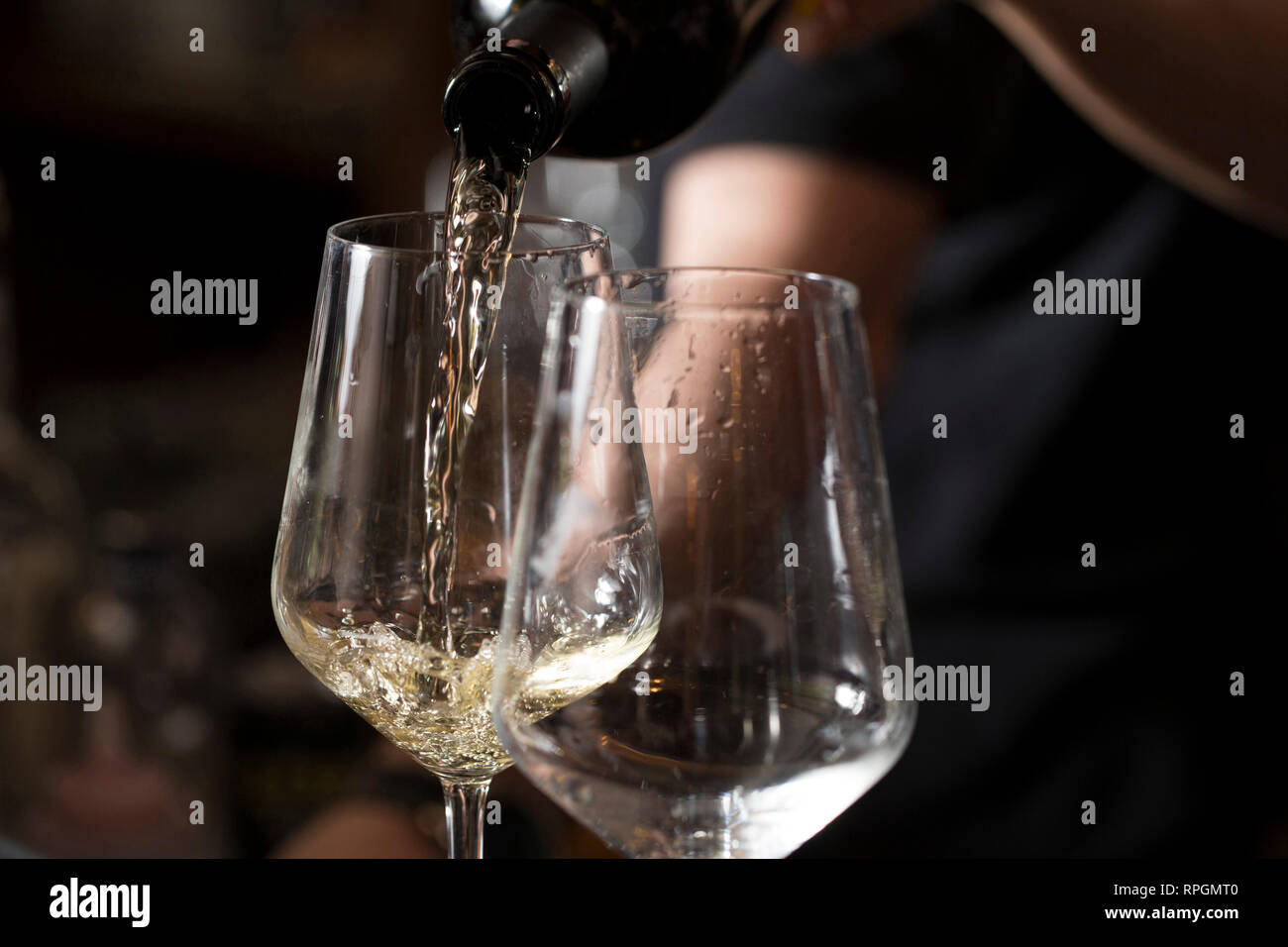 Primo piano di un barista serve due bicchieri di prosecco sulla barra cunter Foto Stock