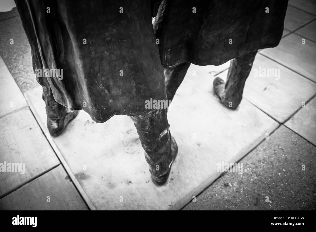 Un drammatico in bianco e nero vista della metà inferiore di due statue in bronzo di Doc Holiday e Wyatt Earp indossare i loro cowboy duster cappotti a sud Foto Stock