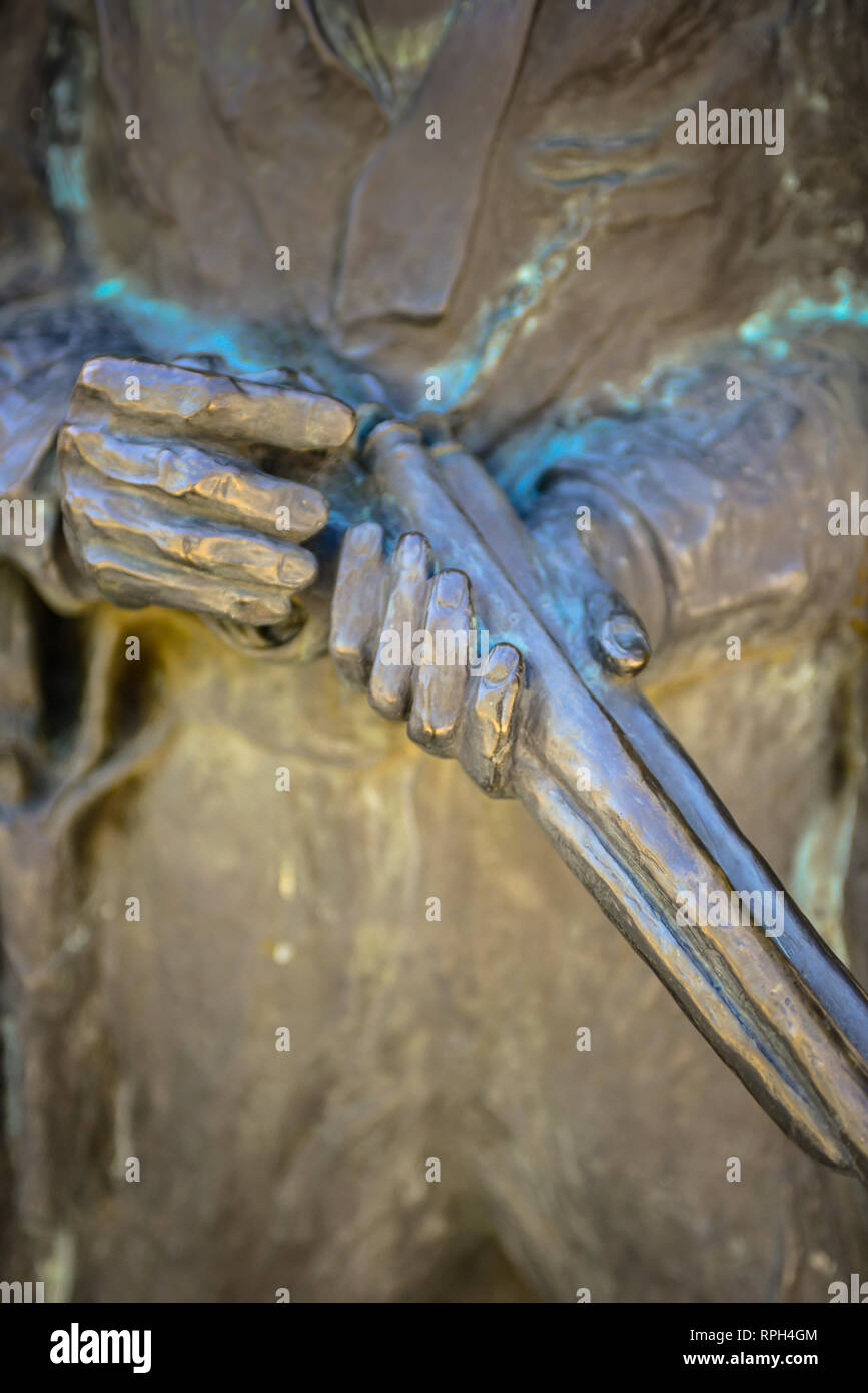 Una drammatica vista ravvicinata di una statua di bronzo di Wyatt Earp caricando il suo fucile a Tucson Railroad Depot pronto ad uccidere Frank Stillwell in Tucson, AZ, Foto Stock