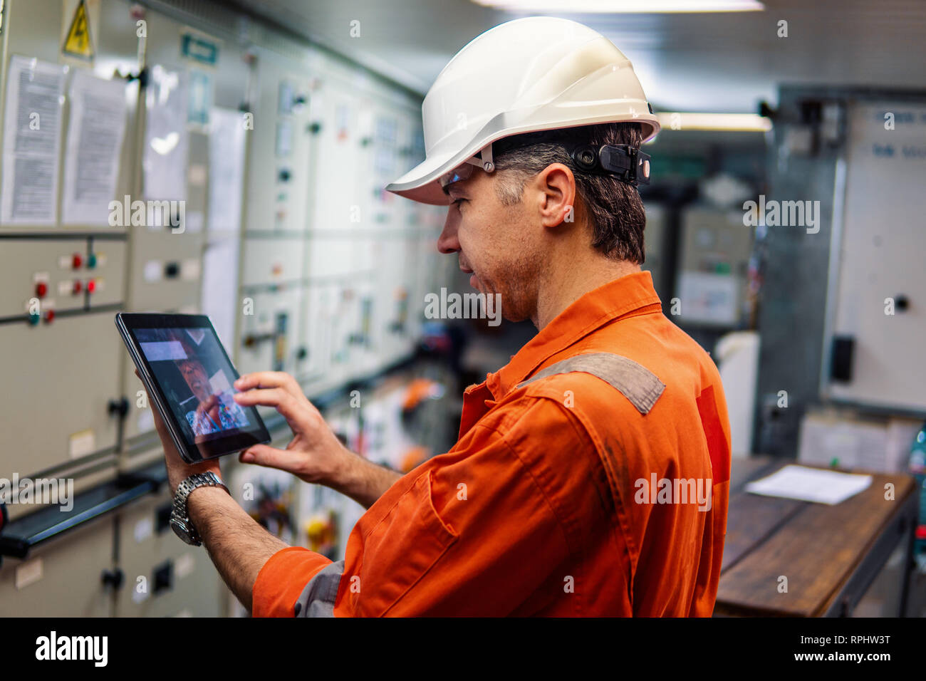 Marine chief engineer guardando la tavoletta digitale del motore in sala di controllo Foto Stock