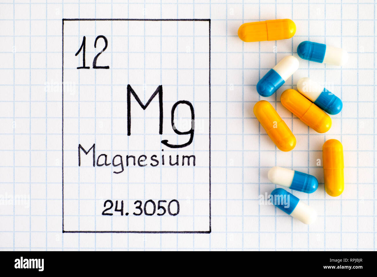 La grafia elemento chimico magnesio Mg con le pillole. Close-up. Foto Stock