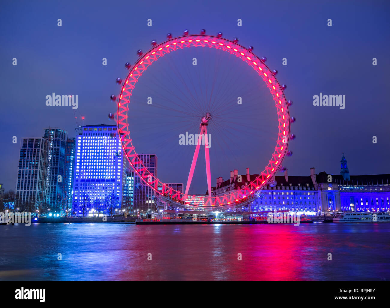Famoso London Eye riflesso della ruota nel Tamigi in serata luci, Regno Unito Foto Stock
