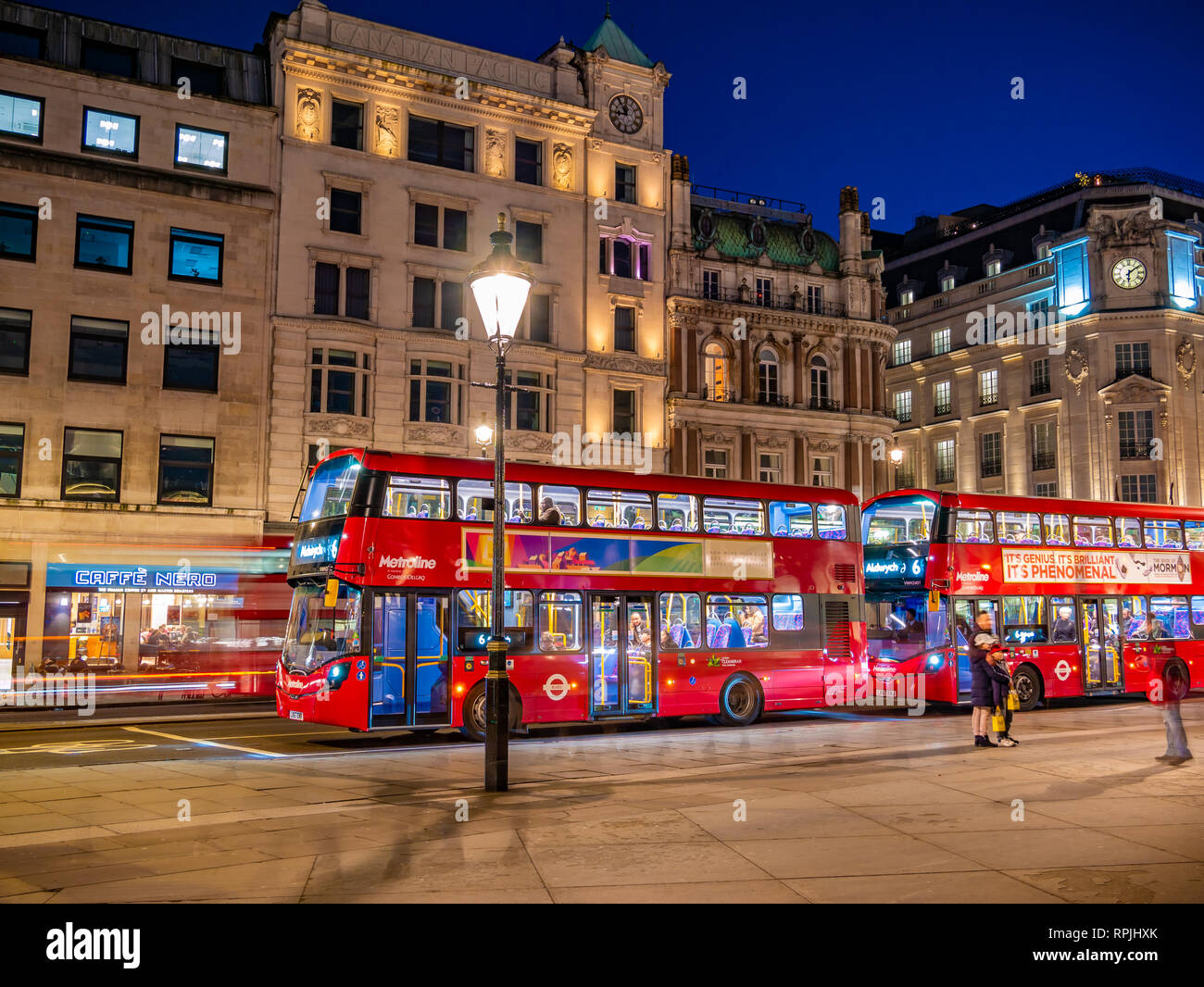 London, England, Regno Unito - 14 Febbraio 2019: Tradizionale bus rosso di Londra in serata luci su strada vicino a Trafalgar Square, Regno Unito Foto Stock
