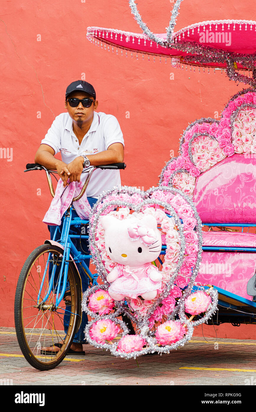 La colorata trishaws, una forma di bicicletta-powered rickshaw, che crociera intorno alla città di Malacca Città, Malaysia Foto Stock