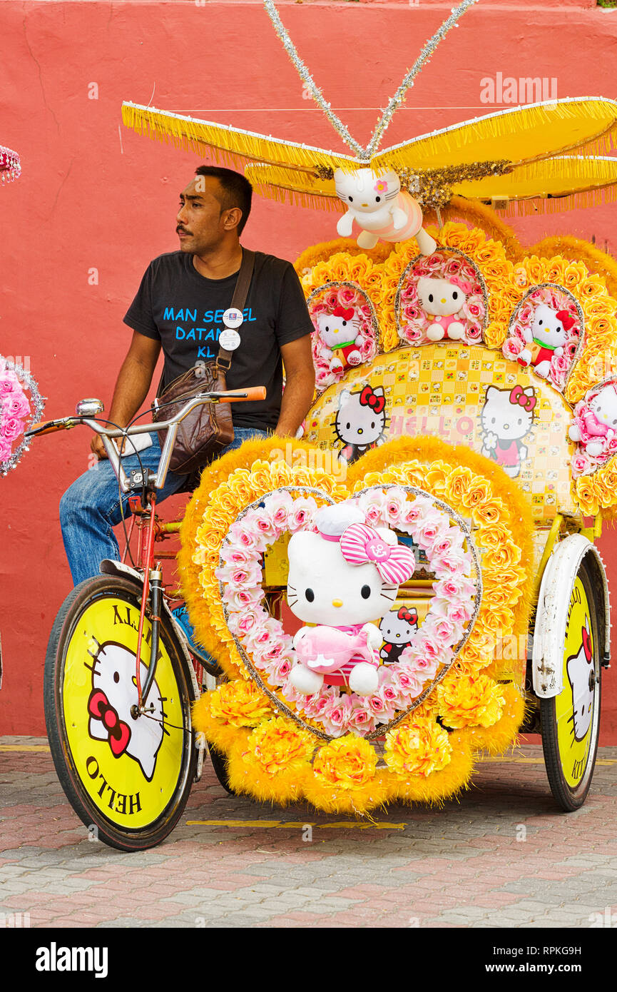 La colorata trishaws, una forma di bicicletta-powered rickshaw, che crociera intorno alla città di Malacca Città, Malaysia Foto Stock