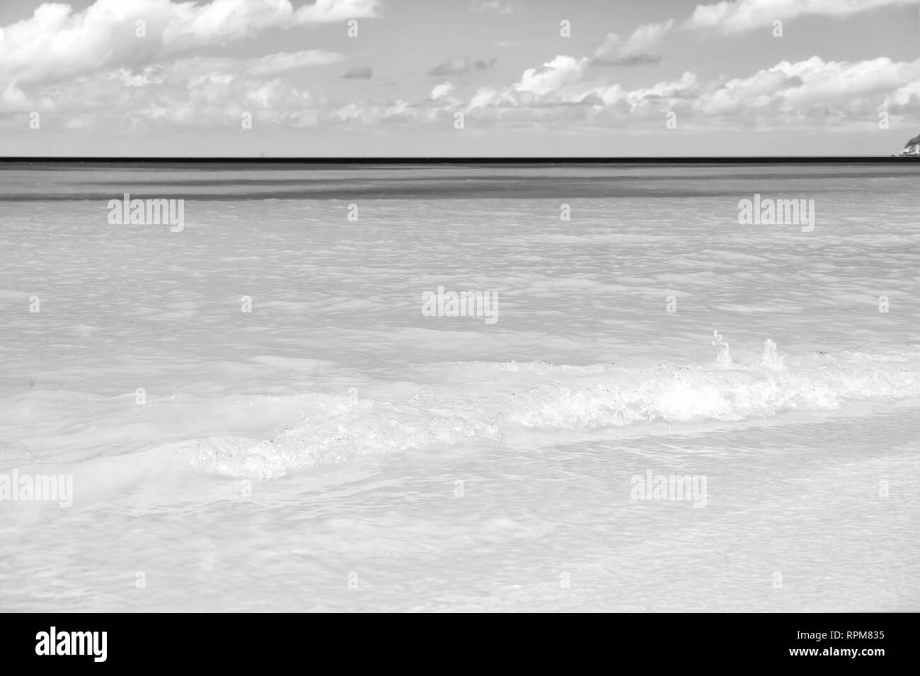 Mare o oceano spiaggia con sabbia bianca e acqua turchese onde in st Johns, Antigua. Seascape sulla giornata di sole su nuvoloso cielo blu sullo sfondo. Estate, vacanza natura, bellezza, paradise, il concetto di libertà. Foto Stock
