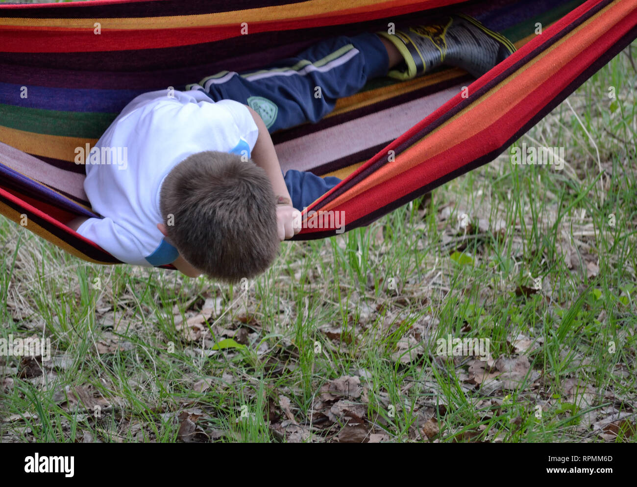 Bambino che gioca con l'amaca e cade giù Foto Stock