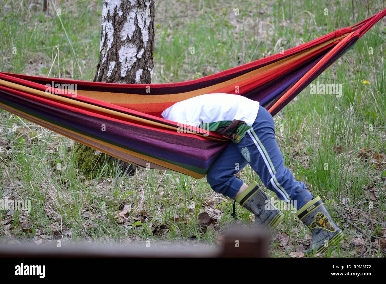 Bambino che gioca con l'amaca e cade giù Foto Stock